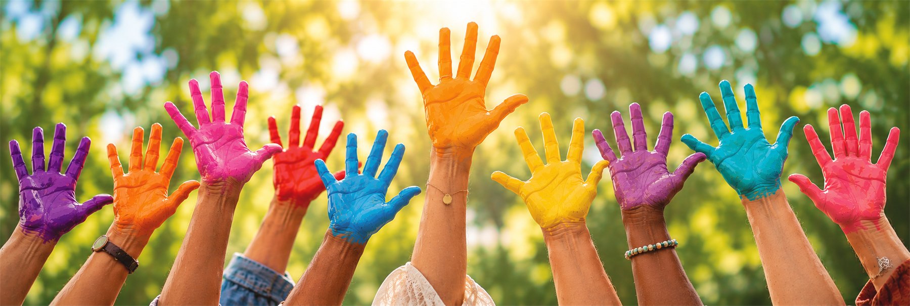 Raised hands painted in bright colours